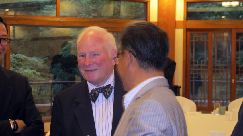 two men in suits are having conversation with each other