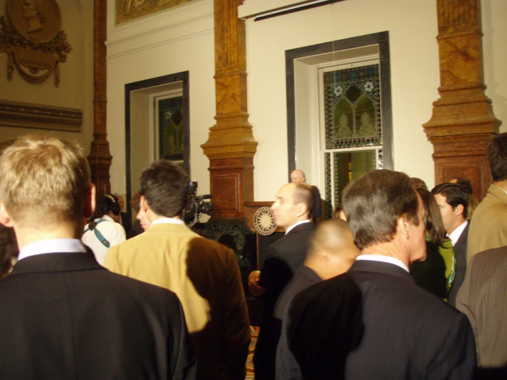 several men in suits walking into a building