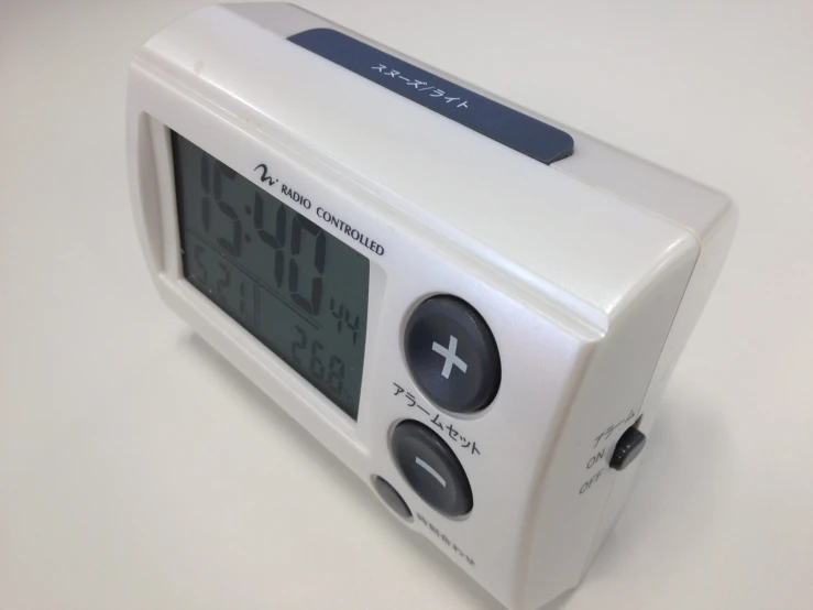 a white alarm clock has an alert display