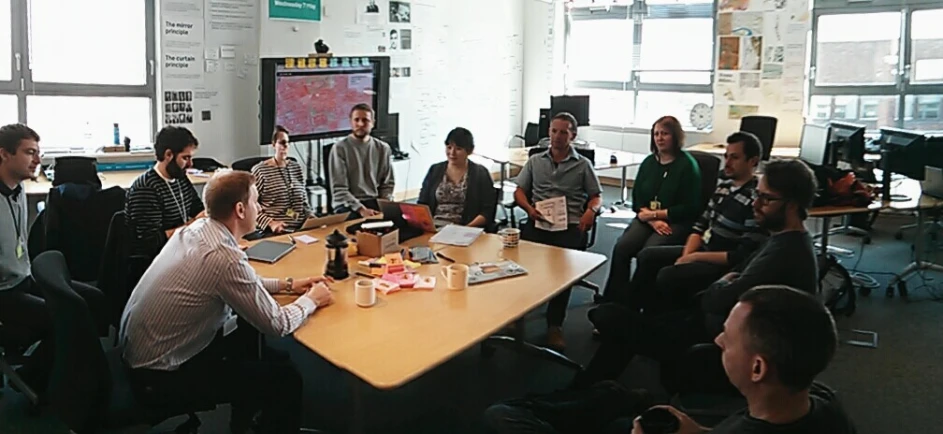 people sitting around a table with drinks and paper work