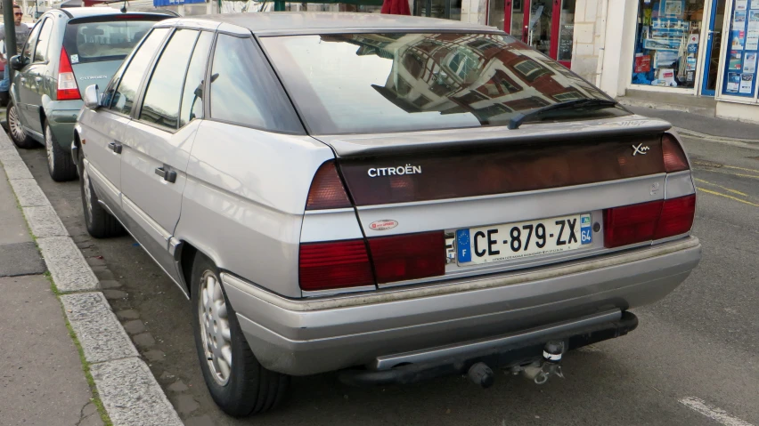 a white station wagon parked on a sidewalk