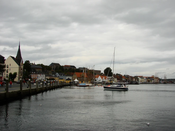 a city on a cloudy day with lots of boats