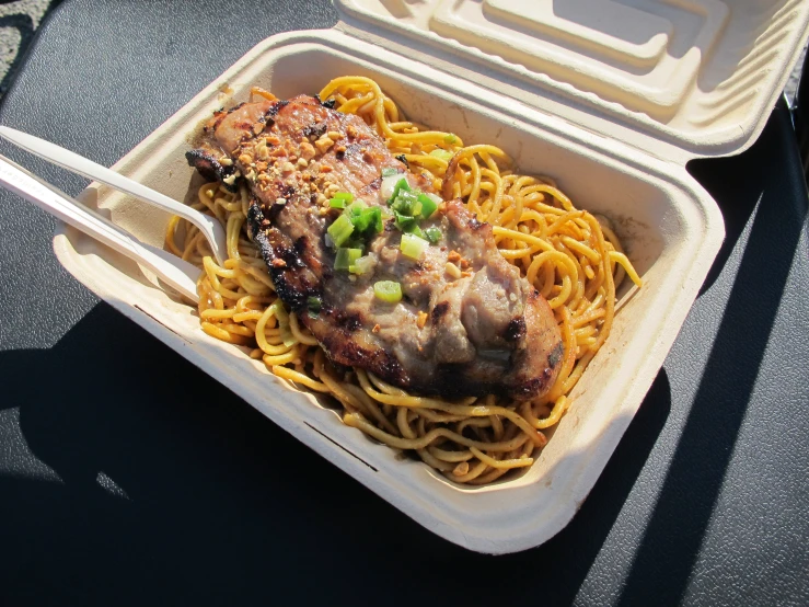 pasta with meat and onions in styrofoam box