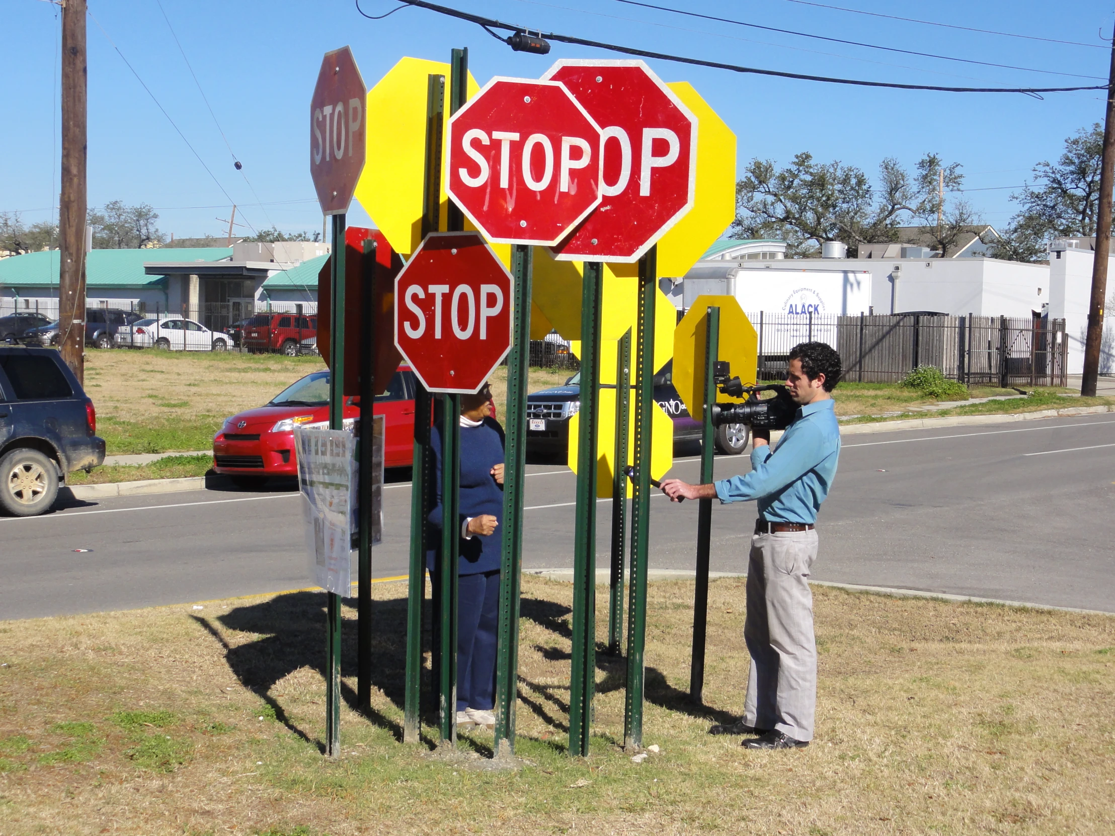 a man holding a stop sign on top of a green pole