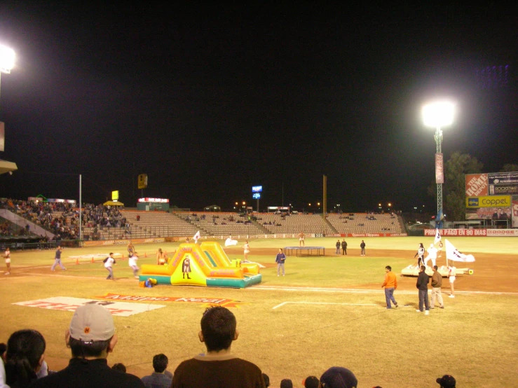 inflatable bouncy castle in an empty baseball field at night