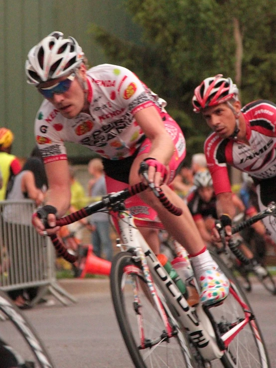 a couple of men riding bicycles down a road