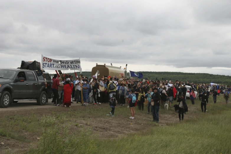 a group of people stand by a van near the forest