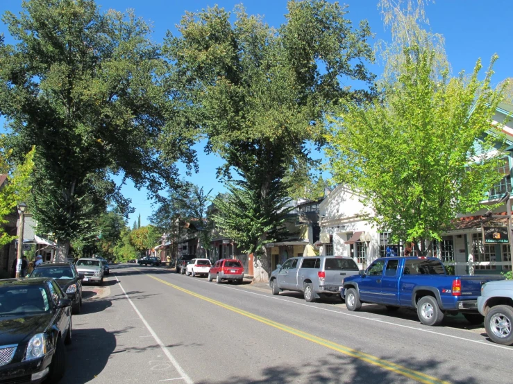 a town street with cars parked and a few buildings on each side