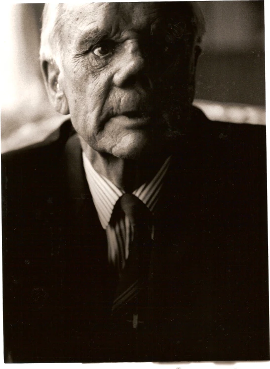 a older man wearing a neck tie looking at the camera