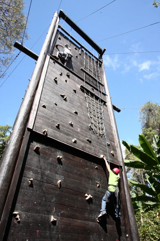 a climber is climbing up the side of a tall tower