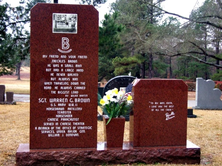 a monument with flowers in vases at the foot of each of its plaques