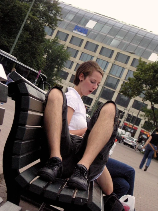 a person with their feet on a bench using a phone