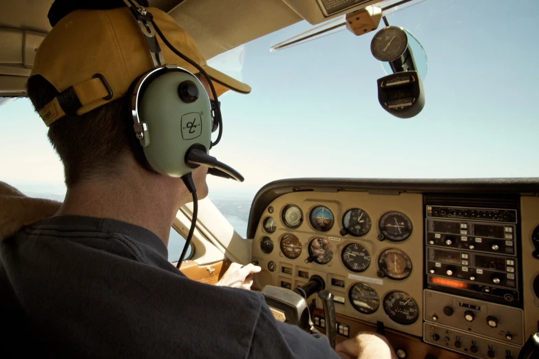 a person wearing headphones while sitting in the cockpit of a helicopter