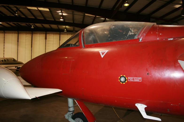 a small red airplane is in a hangar