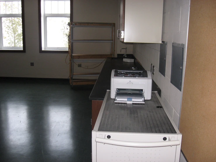 an empty kitchen with a microwave and refrigerator