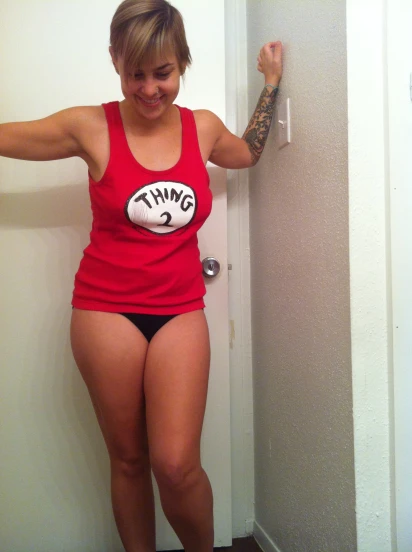 a woman in a red shirt and black shorts wearing a tattoo