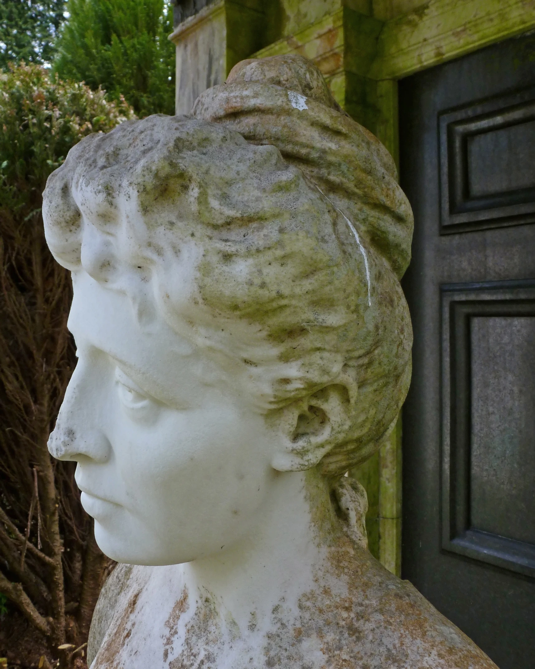 a head sculpture sitting in front of a black door