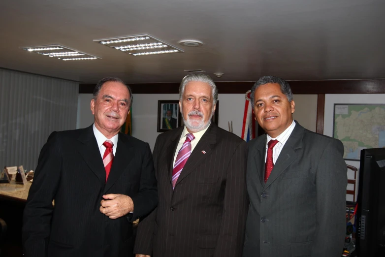 three men in suits standing next to each other