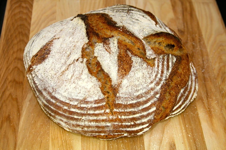 a large loaf of white bread on top of a wooden table