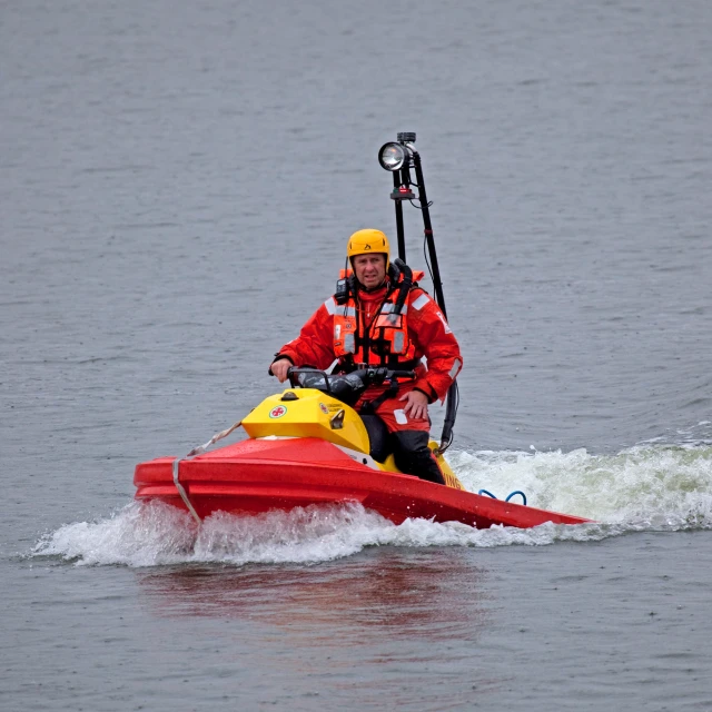 a man wearing red is riding on a yellow boat