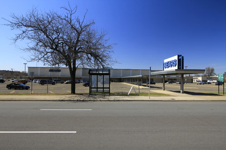 a store sitting next to a tree in a parking lot