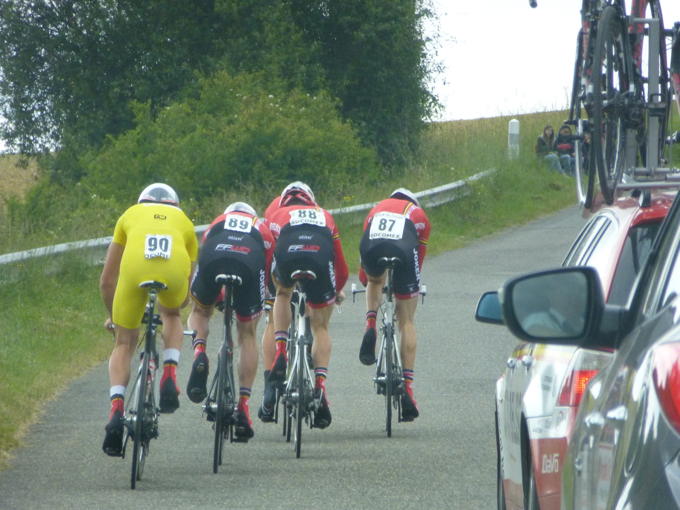 a group of men riding bicycles down a street