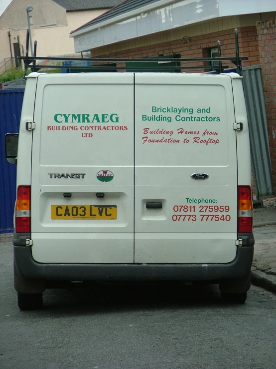 a small white van parked on the side of a road