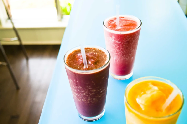 two cups of beverages on a blue table