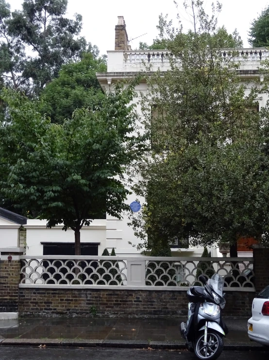 a car and motorcycle parked in front of a house