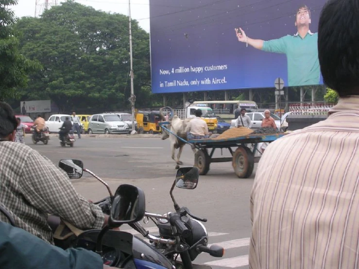 the motorcycles are pulling a large billboard that has a man on it