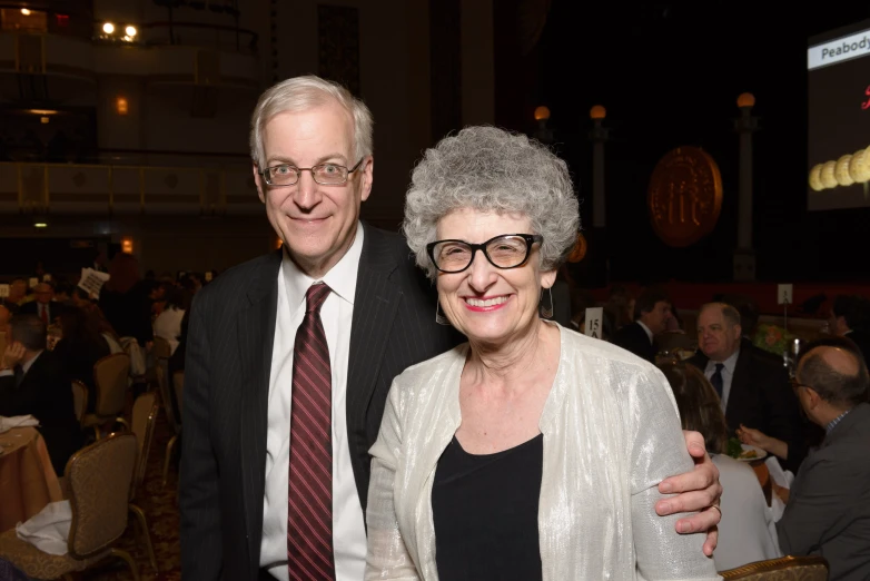 an older couple smiling together in a crowded restaurant