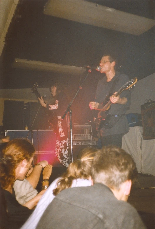 a group of men standing on top of a stage with guitars