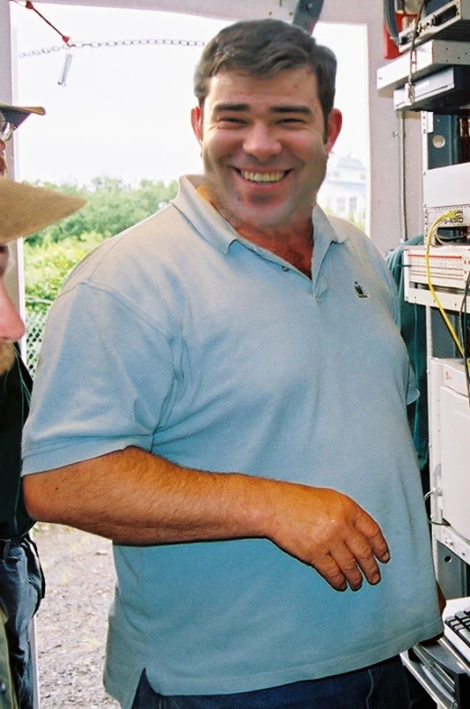 a smiling man in front of some other electronic components