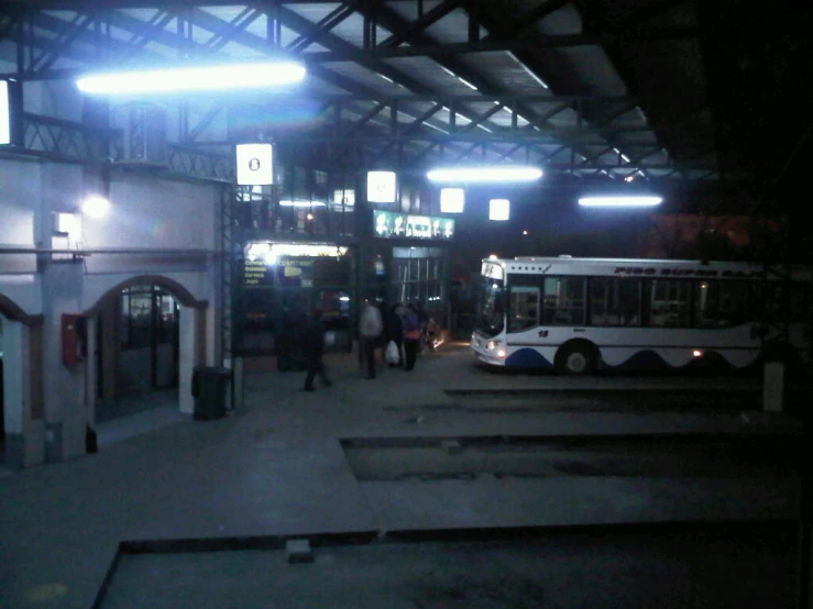 people walking to and from buses in a bus terminal