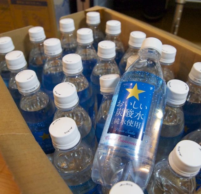 several large bottled water bottles are in a cardboard box