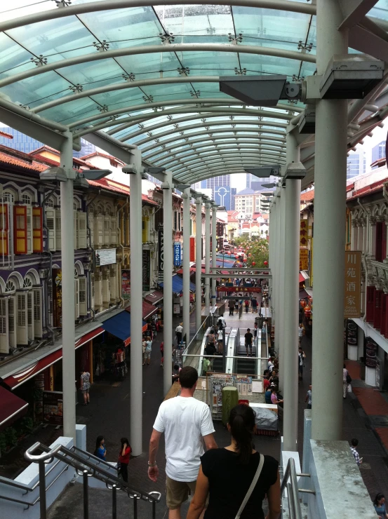 people walk down an indoor covered shopping mall