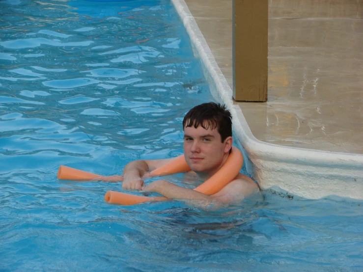 the man is playing with the baseball bats in the swimming pool