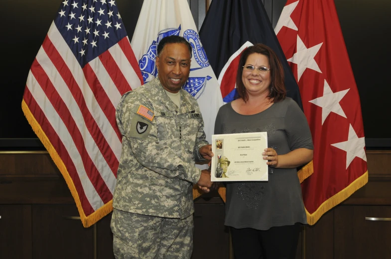 a woman is presented an award by a soldier