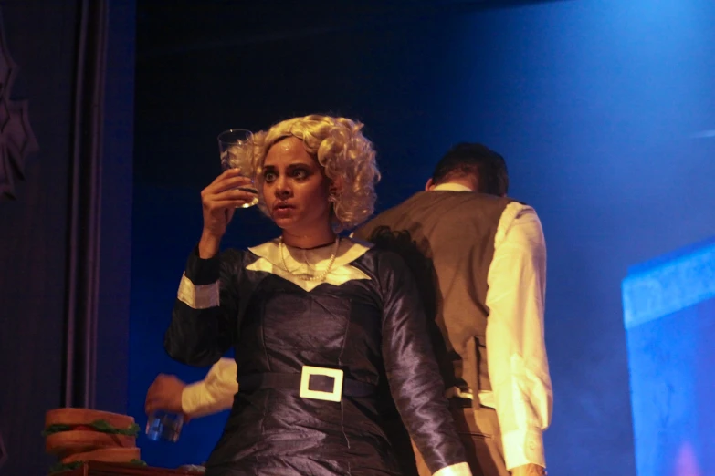 a woman in costume is holding a glass of wine