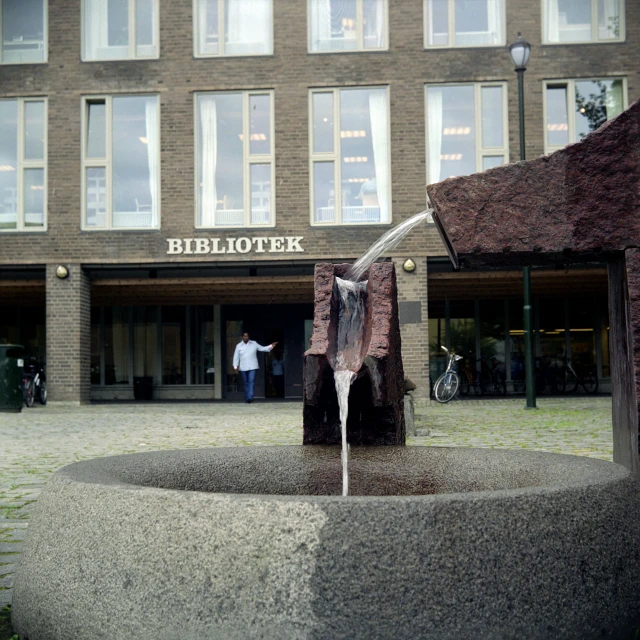 a water fountain in front of a tall building