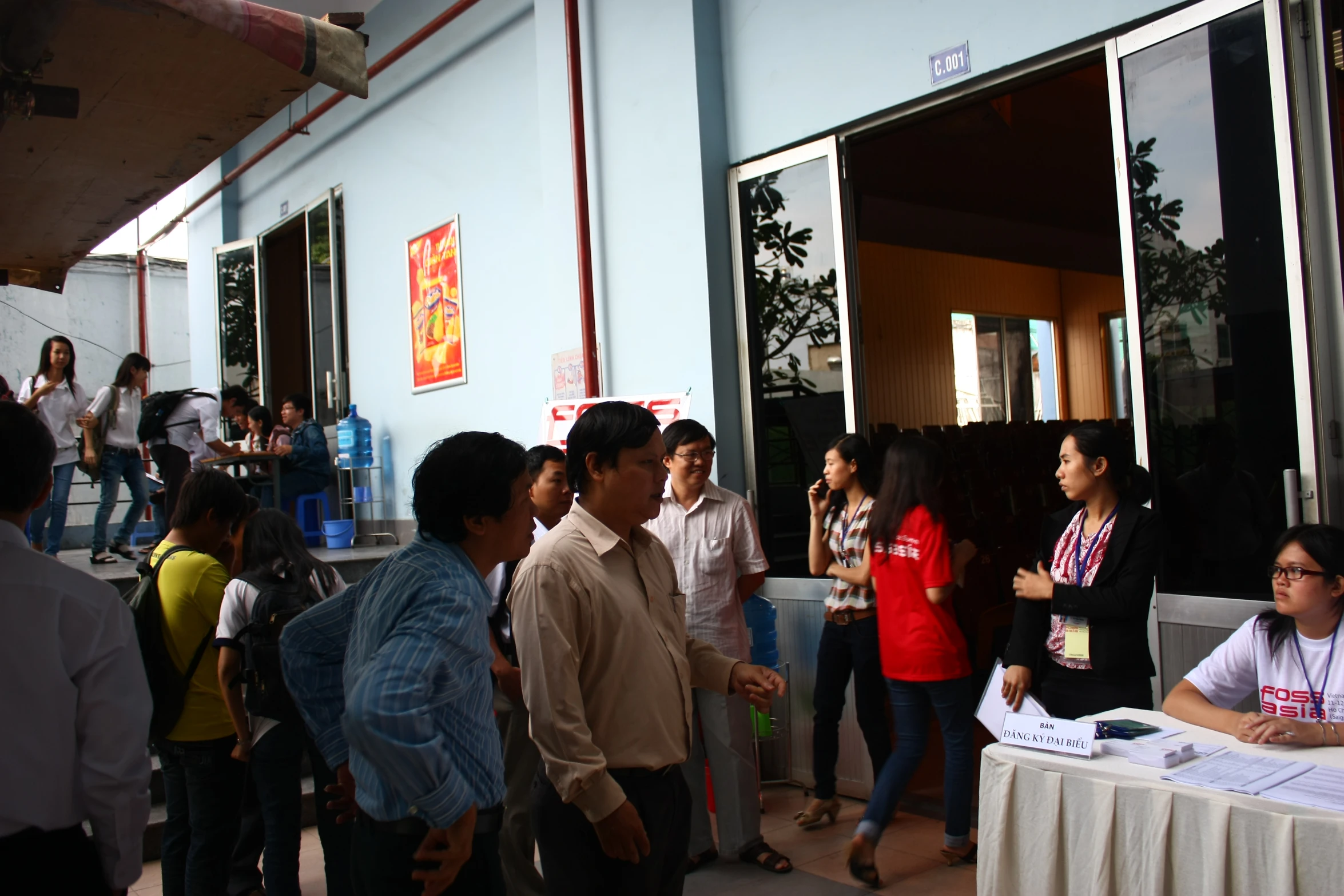 people stand outside in line at an information center