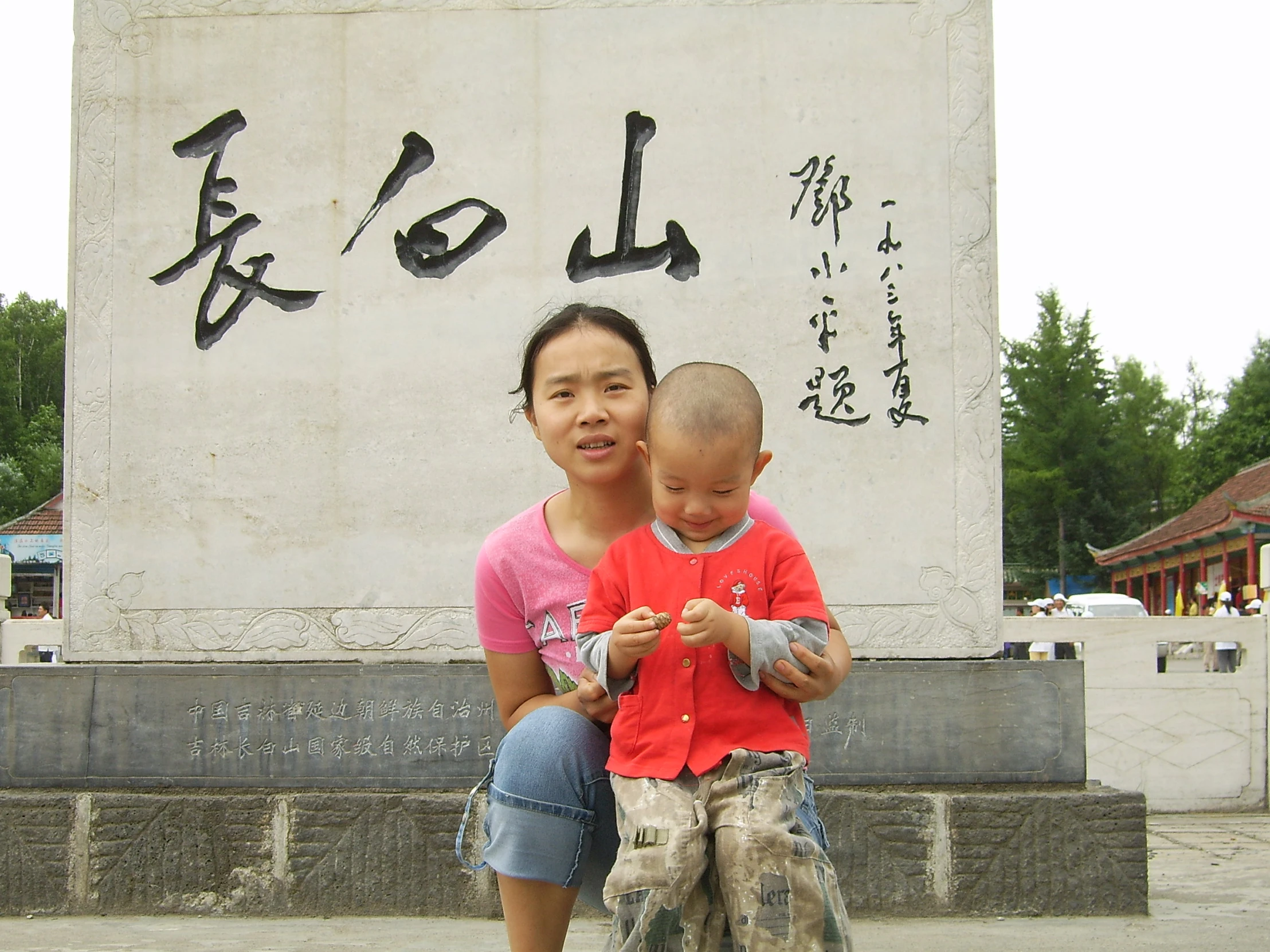 the woman is sitting on her child with asian writing