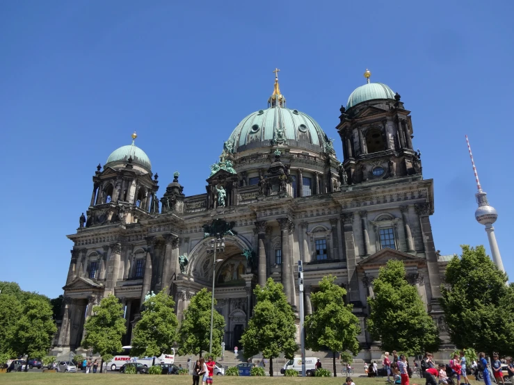 a large building with two domed towers near by people