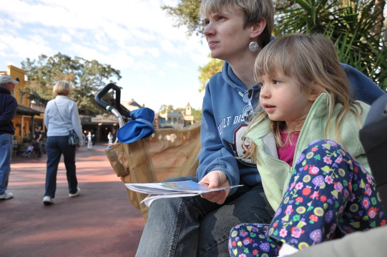 a little girl that is sitting on the lap of her dad