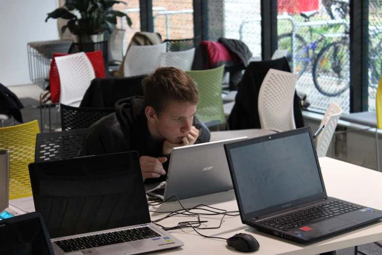 a man sitting at a table using his laptop