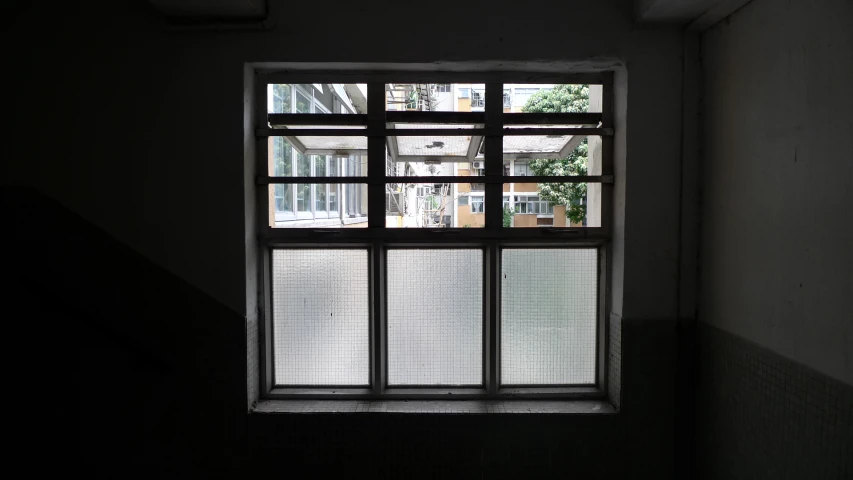 the inside of a dark room that has a small window with bars