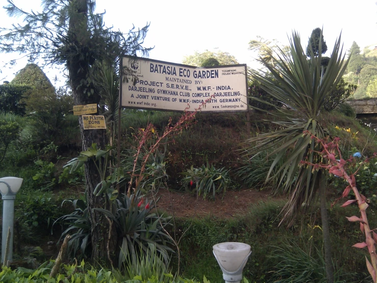 a garden sign in english and thai writing