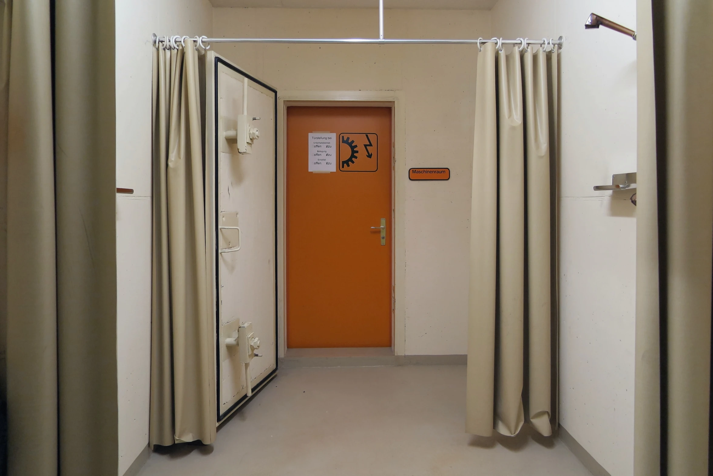 a hallway with no doors and orange door handle