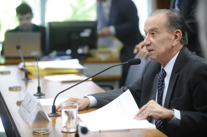 a man sitting at a table with paperwork in front of him