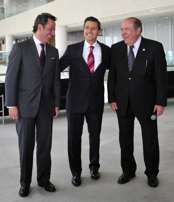 three men stand side by side in suits and ties